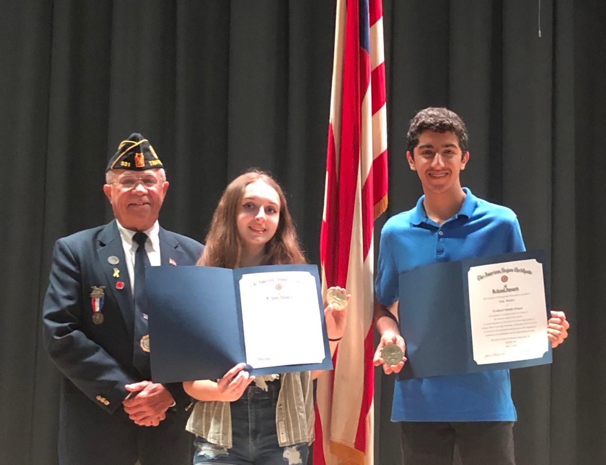 Jim Drnjenich, commander of Trafford American Legion, presents awards to Chloe Bishop and Faiz  Khatri