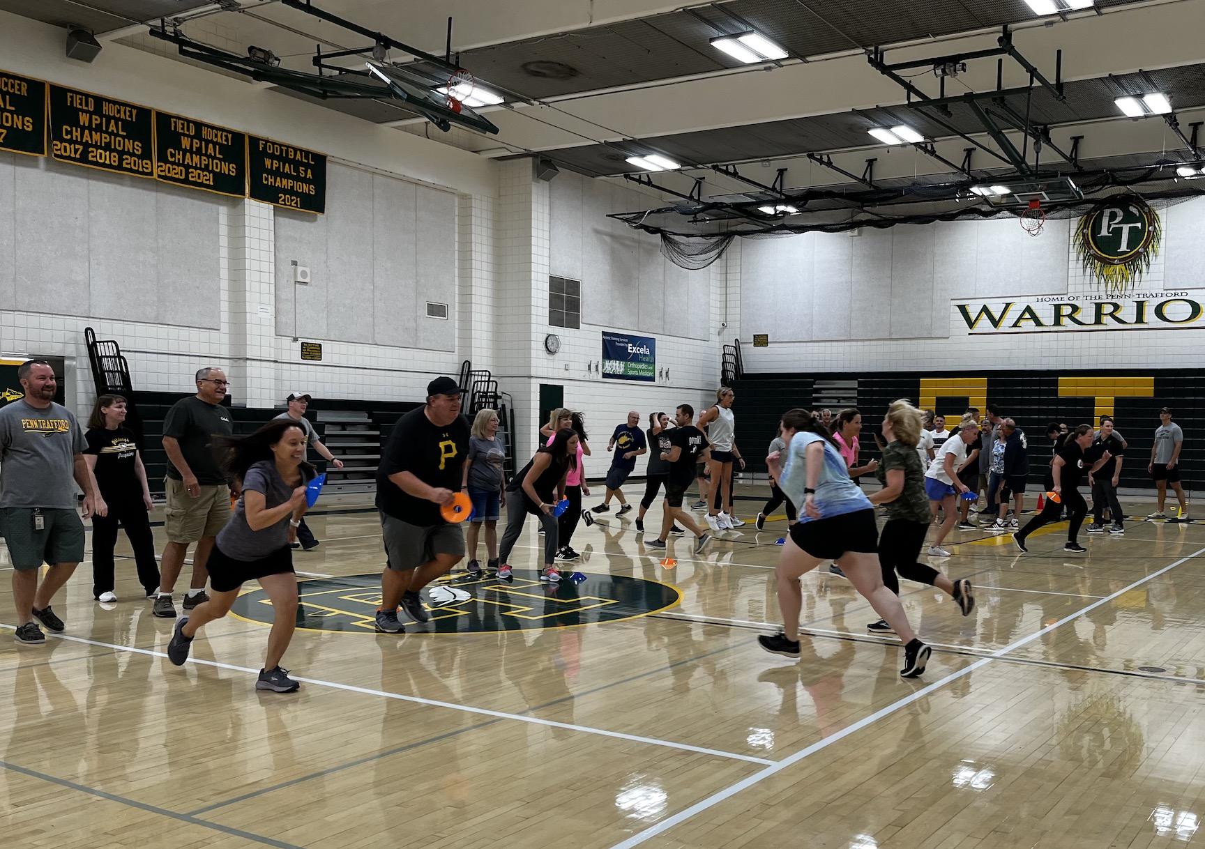 Teachers participate in a wellness exercise let by FSQ