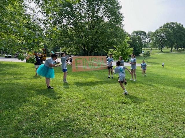 Phys Ed teacher, Mrs. Yackovich, records time while 7th-grader Joey Aquino crosses the finish line