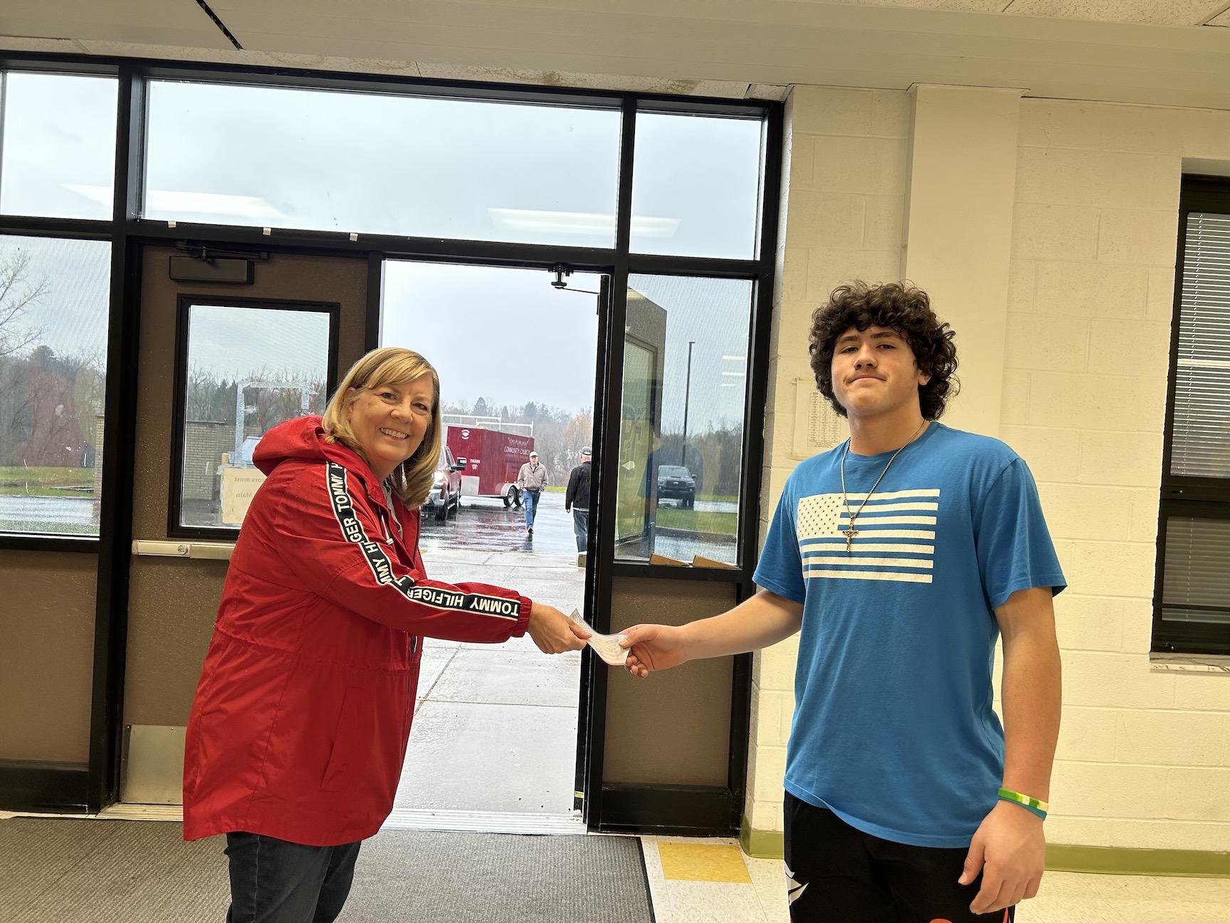 Mrs. French from Community United Methodist Church accepts a monetary donation from Tanner DeStefano